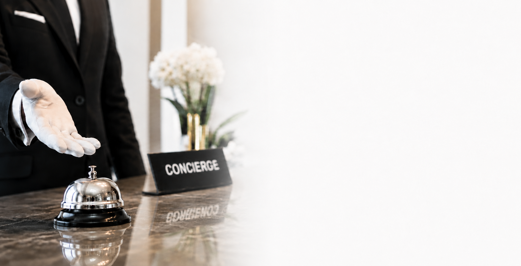 A hotel concierge in white gloves beside a service bell — symbolising Settla's high-touch white-glove approach to B2B payments